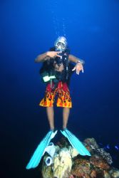 Our dive guide with his colorful shorts hovers above a Ch... by Terry Moore 
